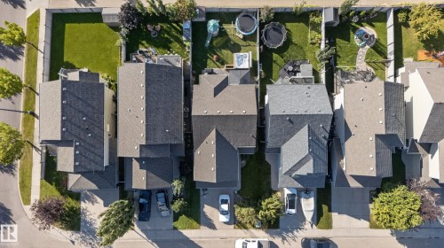 Asphalt shingle roofing, paved driveways, private fenced backyards, and mature street trees - 1332 72 Street Sw, Edmonton, AB 