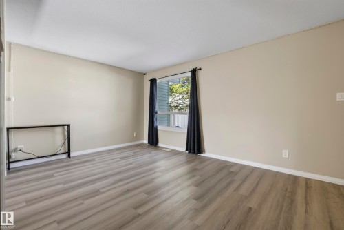 Wood-finish flooring with light-toned wall paint and white trim - 141 Dickinsfield Court Nw, Edmonton, AB 