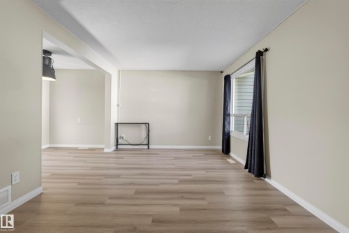 Wood-finish flooring throughout, neutral wall tones, and a window with blinds - 141 Dickinsfield Court Nw, Edmonton, AB 
