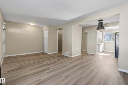 Expansive wood-finish flooring throughout, complemented by a contemporary pendant light fixture - 141 Dickinsfield Court Nw, Edmonton, AB 