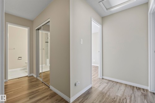 Wood-finish flooring throughout the hall - 141 Dickinsfield Court Nw, Edmonton, AB 