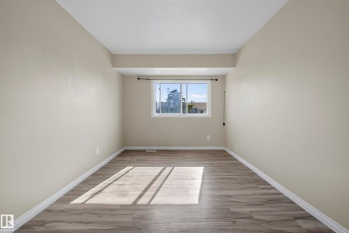 Wood-finish flooring, neutral wall tones, and a white-framed window - 141 Dickinsfield Court Nw, Edmonton, AB 