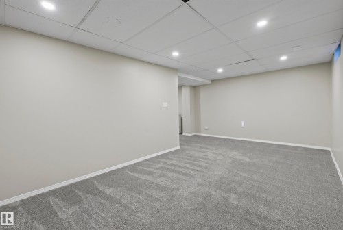 Recessed lighting, gray carpeting, neutral wall paint, white trim, acoustical tile ceiling - 141 Dickinsfield Court Nw, Edmonton, AB 