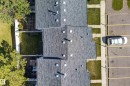 Dark shingle roofing, private fenced yards, green lawn space, mature trees, and paved parking area - 141 Dickinsfield Court Nw, Edmonton, AB 