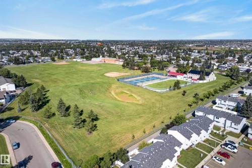 Expansive green space featuring athletic fields, paved tennis courts, and mature trees - 141 Dickinsfield Court Nw, Edmonton, AB 