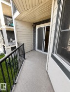 Private balcony with a sliding glass door and black metal railing - 