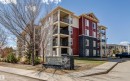 Modern multi-story building featuring red siding and dark stone veneer - #208 18122 77 St Nw, Edmonton, AB 