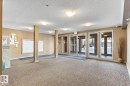 Entry foyer featuring carpet flooring and multiple flush-mount ceiling lights - #208 18122 77 St Nw, Edmonton, AB 