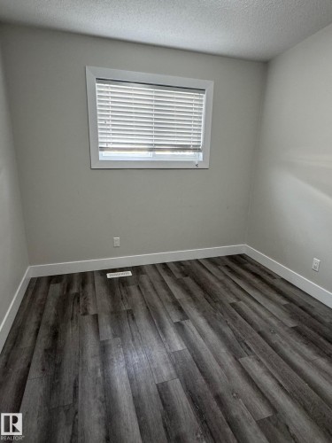 Bedroom featuring wood-finish flooring and a single window with blinds - 7604 7606 75 Street Nw, Edmonton, AB - Indoor Photo Showing Other Room