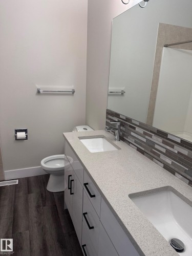 Double vanity featuring integrated rectangular sinks and light-colored countertops - 7604 7606 75 Street Nw, Edmonton, AB - Indoor Photo Showing Bathroom