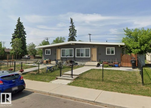 Contemporary gray duplex with white trim, featuring two front entrances and a chain-link fenced front yard - 7604 7606 75 Street Nw, Edmonton, AB - Outdoor