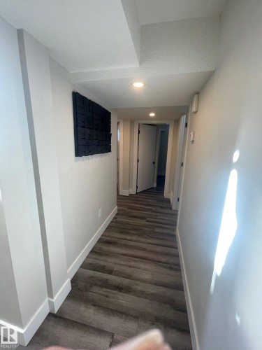 Hallway featuring wood-finish flooring, recessed lighting, white baseboards, and light-toned walls - 7604 7606 75 Street Nw, Edmonton, AB - Indoor Photo Showing Other Room