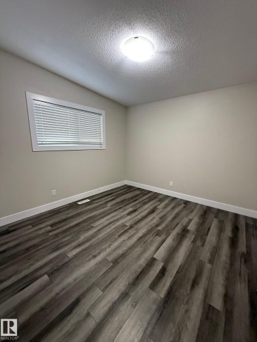 Neutral wall finishes with a single window featuring horizontal blinds - 7604 7606 75 Street Nw, Edmonton, AB - Indoor Photo Showing Other Room