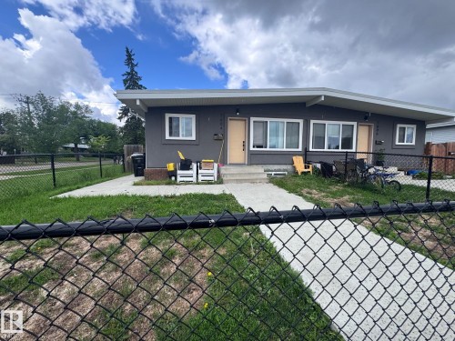 Duplex-style property featuring a grey exterior with white trim windows and two light-toned entry doors - 7604 7606 75 Street Nw, Edmonton, AB - Outdoor