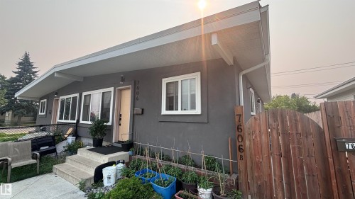 Contemporary split-level facade featuring a charcoal gray stucco exterior, white trim, and multiple white-framed windows - 7604 7606 75 Street Nw, Edmonton, AB - Outdoor With Exterior