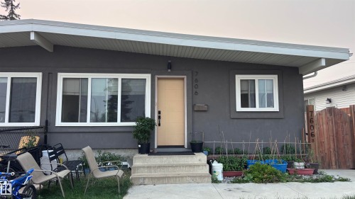 Gray stucco exterior featuring a light-colored entry door, white window frames, and exterior lighting - 7604 7606 75 Street Nw, Edmonton, AB - Outdoor