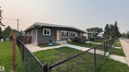 Duplex property with a neutral gray stucco exterior, white window trim, and a light-colored front door - 7604 7606 75 Street Nw, Edmonton, AB - Outdoor