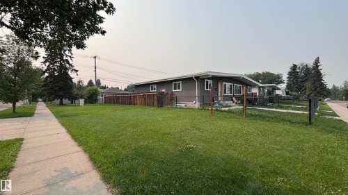 Ranch-style residence featuring a dark gray exterior, white trim, and a prominent front lawn - 7604 7606 75 Street Nw, Edmonton, AB - Outdoor