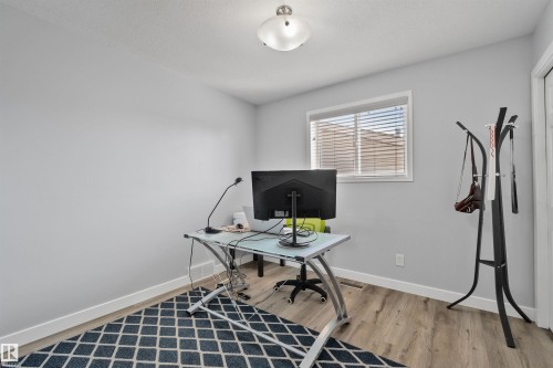 Set up as an office. Recessed window with blinds, wood-finish flooring, and light wall color - 18812 89 Avenue Nw, Edmonton, AB 
