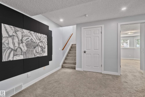 Carpeted flooring, recessed lighting, white trim, and a paneled interior door with dark hardware - 18812 89 Avenue Nw, Edmonton, AB 