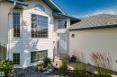 Exterior featuring white horizontal siding, multiple transom windows, an arched window, and a shingled roof - 18812 89 Avenue Nw, Edmonton, AB 