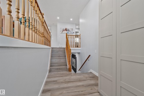 Wood-finish flooring, light grey walls, white trim, wood railings, and built-in storage cabinets - 18812 89 Avenue Nw, Edmonton, AB 