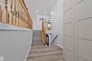 Wood-finish flooring, light grey walls, white trim, wood railings, and built-in storage cabinets - 18812 89 Avenue Nw, Edmonton, AB 