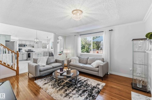 Hardwood flooring, kitchen with stainless steel appliances, contemporary pendant lighting, recessed lighting, and a decorative ceiling fixture - 522 Klarvatten Lake Wynd Nw, Edmonton, AB 