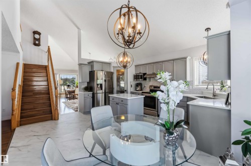 Kitchen featuring stainless steel appliances, light gray cabinetry, and a white tile backsplash - 522 Klarvatten Lake Wynd Nw, Edmonton, AB 