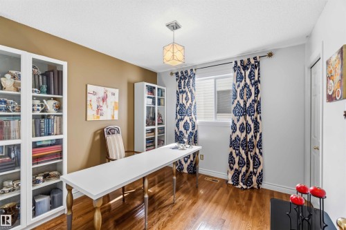 Wood-finish flooring, built-in shelving, a large window, and an overhead light fixture - 522 Klarvatten Lake Wynd Nw, Edmonton, AB 