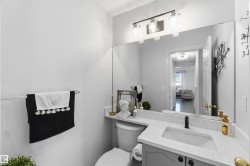 Vanity with a solid surface countertop, undermount sink, and a wall-mounted mirror - 