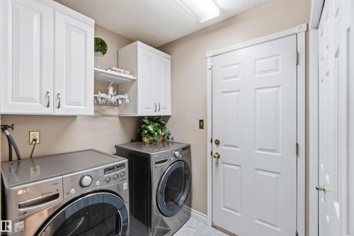 White paneled cabinetry, light neutral wall color, and a flush-mount ceiling light fixture - 522 Klarvatten Lake Wynd Nw, Edmonton, AB 