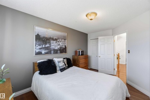 Warm wood-finish flooring, neutral wall tones, white trim, and a ceiling-mounted light fixture - 522 Klarvatten Lake Wynd Nw, Edmonton, AB 