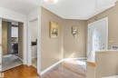 Foyer featuring wood-finish flooring, a decorative glass-paneled entry door, and painted walls - 522 Klarvatten Lake Wynd Nw, Edmonton, AB 