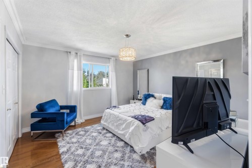 Hardwood flooring, painted walls, crown molding, double-door closet, and a multi-pane window - 522 Klarvatten Lake Wynd Nw, Edmonton, AB 