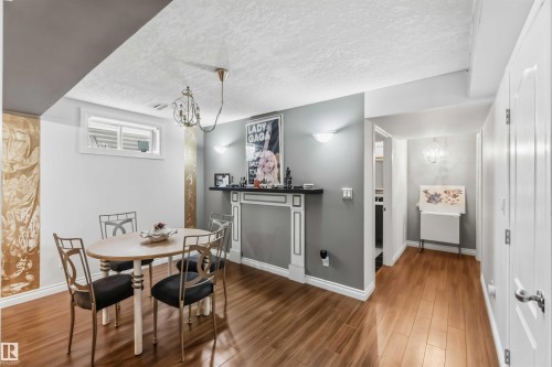 Hardwood-finish flooring, built-in decorative fireplace with mantel, recessed window, white baseboards, and white paneled doors - 522 Klarvatten Lake Wynd Nw, Edmonton, AB 
