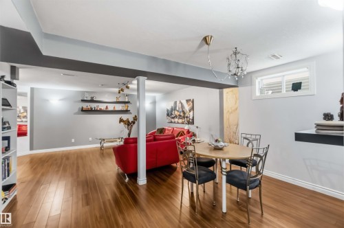 Wood-finish flooring, recessed lighting, white built-in shelving, column detail, and a single window - 522 Klarvatten Lake Wynd Nw, Edmonton, AB 