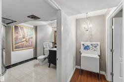 Bathroom featuring tile flooring, a curved glass shower enclosure, and a vanity with a dark finish - 