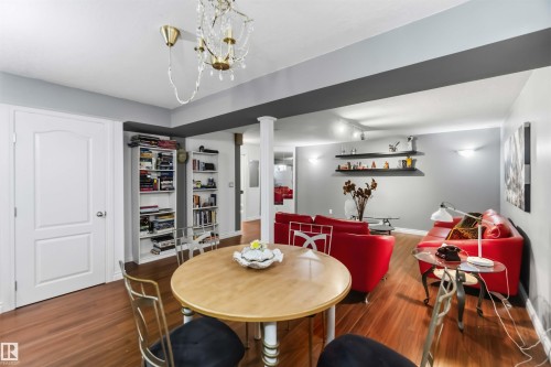 Wood-finish flooring throughout, white interior doors, built-in shelving, recessed lighting, and a decorative chandelier - 522 Klarvatten Lake Wynd Nw, Edmonton, AB 