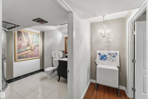 Bathroom featuring tile flooring, a curved glass shower enclosure, and a vanity with a dark finish - 522 Klarvatten Lake Wynd Nw, Edmonton, AB 
