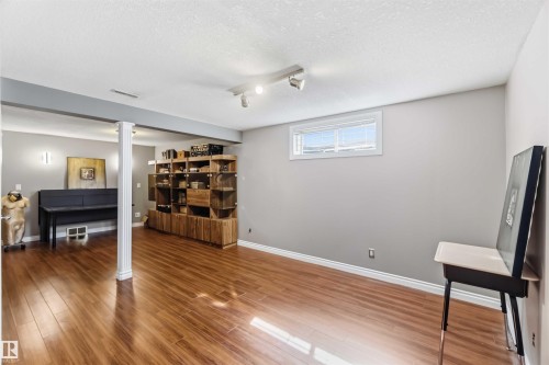 Wood-finish flooring throughout, recessed window, track lighting, and a built-in wood shelving unit - 522 Klarvatten Lake Wynd Nw, Edmonton, AB 