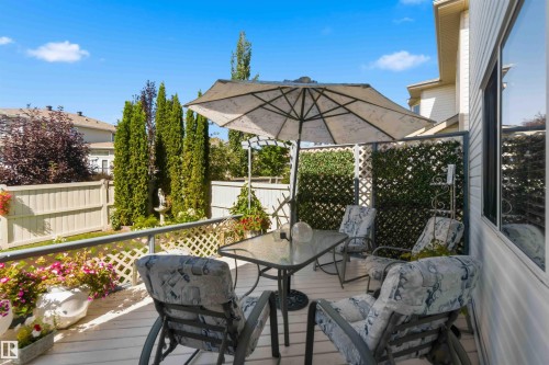 Private deck with lattice fencing, mature privacy landscaping, and a garden fountain - 522 Klarvatten Lake Wynd Nw, Edmonton, AB 