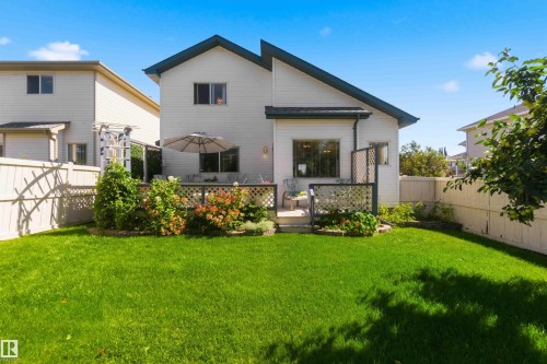 Expansive lawn with mature perimeter landscaping, private patio, and lattice fencing - 522 Klarvatten Lake Wynd Nw, Edmonton, AB 