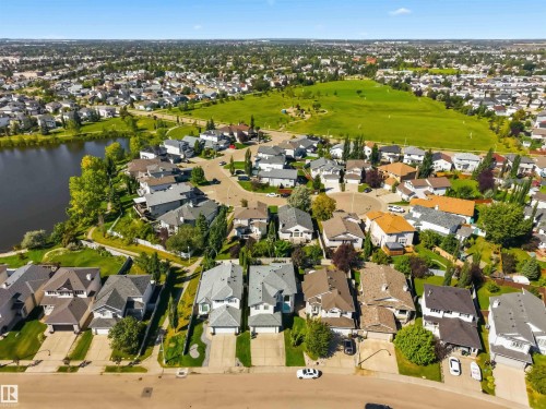 Residential neighborhood featuring a lake, green space, and mature trees - 522 Klarvatten Lake Wynd Nw, Edmonton, AB 