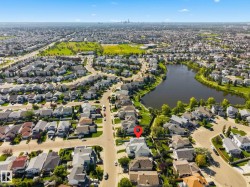 Lakeside residential area with mature trees and paved roads, featuring a prominent body of water - 