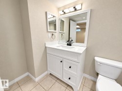 White vanity with an integrated sink, black faucet, and white framed mirror - 