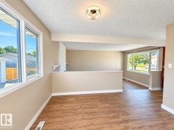 Wood-finish flooring, neutral wall tones, white trim, recessed lighting, and large windows - 