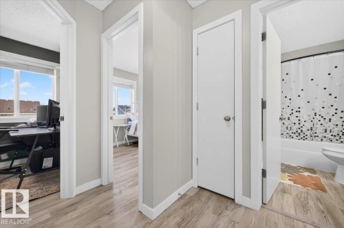 Wood-finish flooring throughout the hallway - 1217 76 Street Sw, Edmonton, AB 