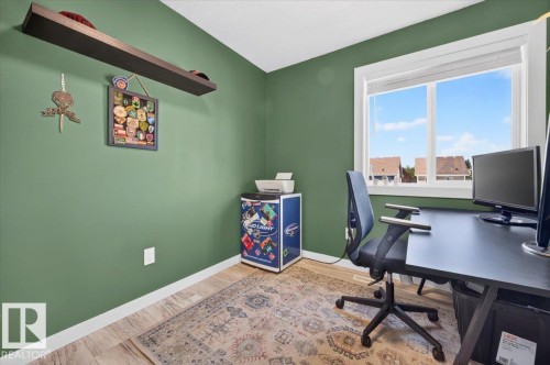 Wood-finish flooring, a large window with white trim, and a built-in floating shelf - 1217 76 Street Sw, Edmonton, AB 