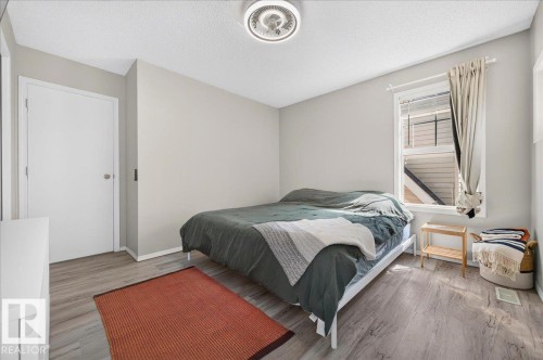 Wood-finish flooring, neutral wall tones, white trim, and a ceiling-mounted light fixture - 1217 76 Street Sw, Edmonton, AB 